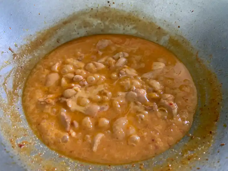 Simmering panang chicken curry in rich coconut sauce.