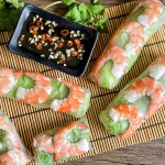 Goi cuon, Vietnamese spring rolls with shrimp and lettuce next to a bowl of garlic chili fish sauce.