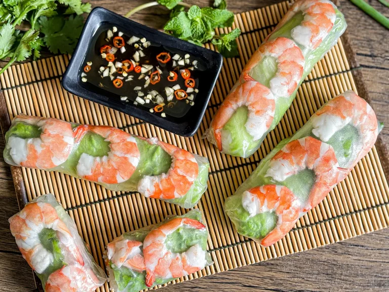 Goi cuon, Vietnamese spring rolls with shrimp and lettuce next to a bowl of garlic chili fish sauce.