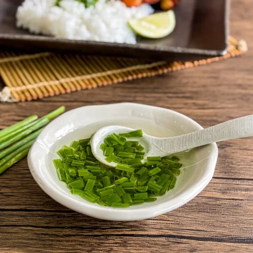 Vietnamese mo hanh scallion oil with chopped green onions in a small white dish, ready to spoon over rice or noodles.