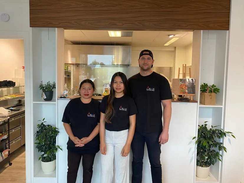 Praew with team members at her Thai restaurant kitchen entrance.