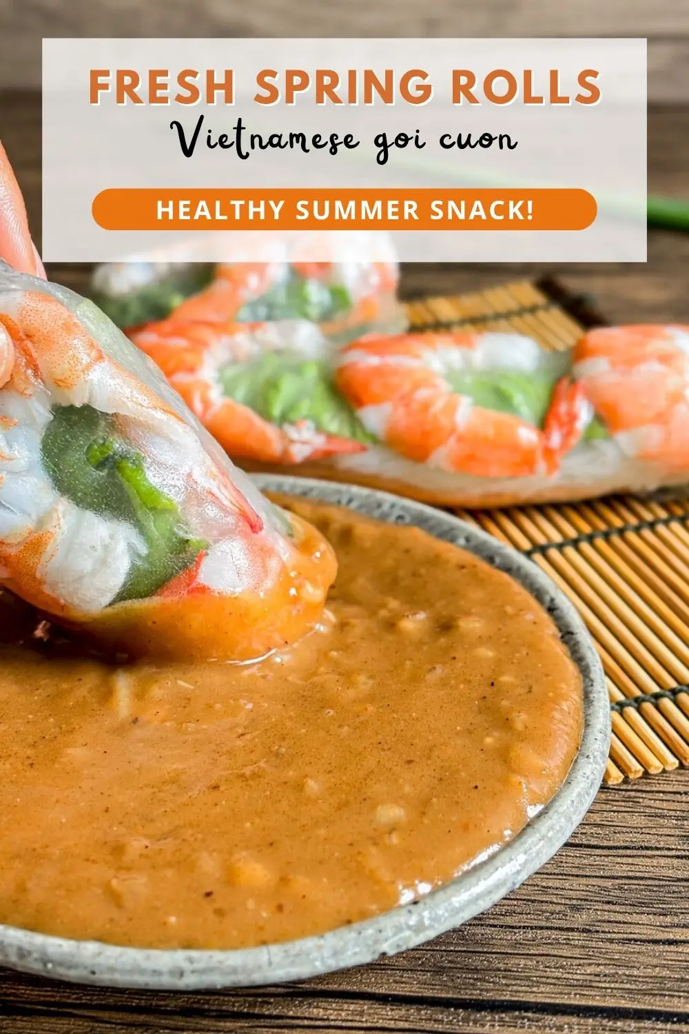 Vietnamese fresh spring rolls with shrimp, herbs, and vermicelli dipped into creamy peanut sauce on a plate.