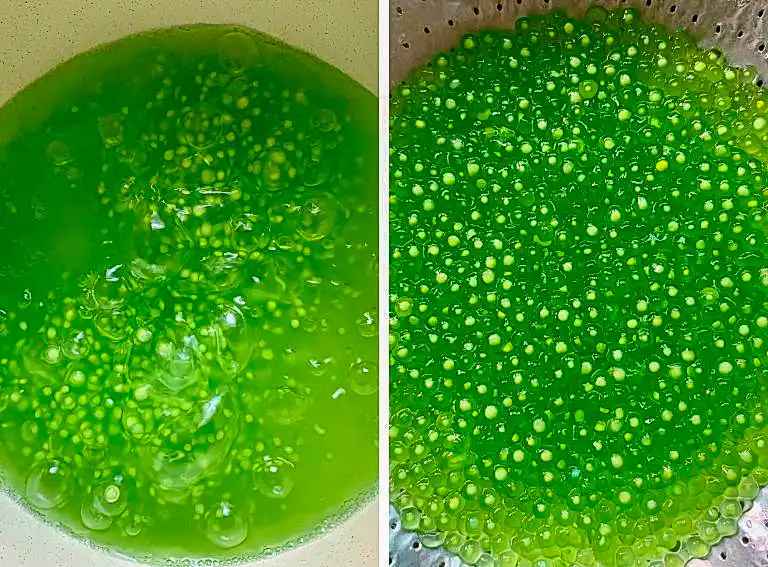 Green pandan tapioca pearls boiling in a pot and drained in a strainer.
