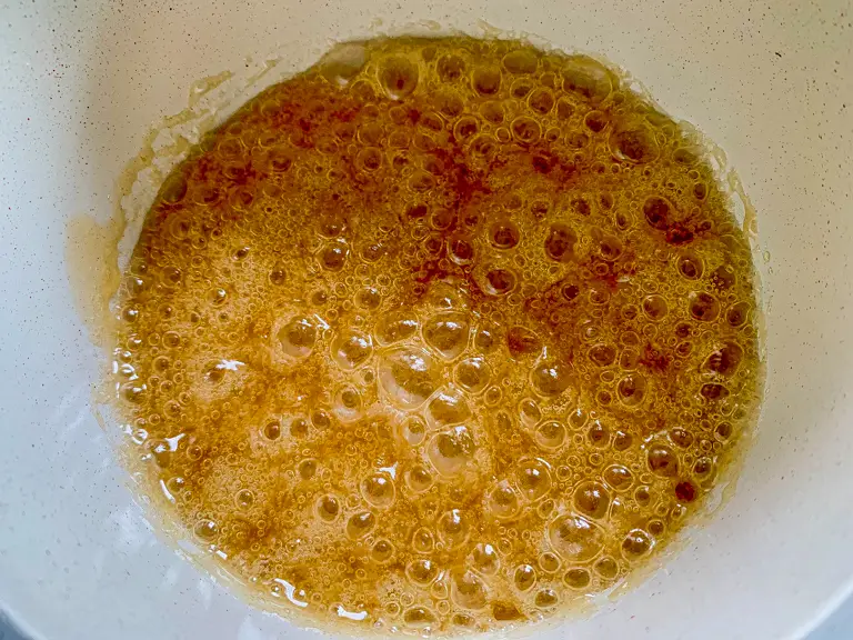 Palm sugar melting and caramelizing in pot.