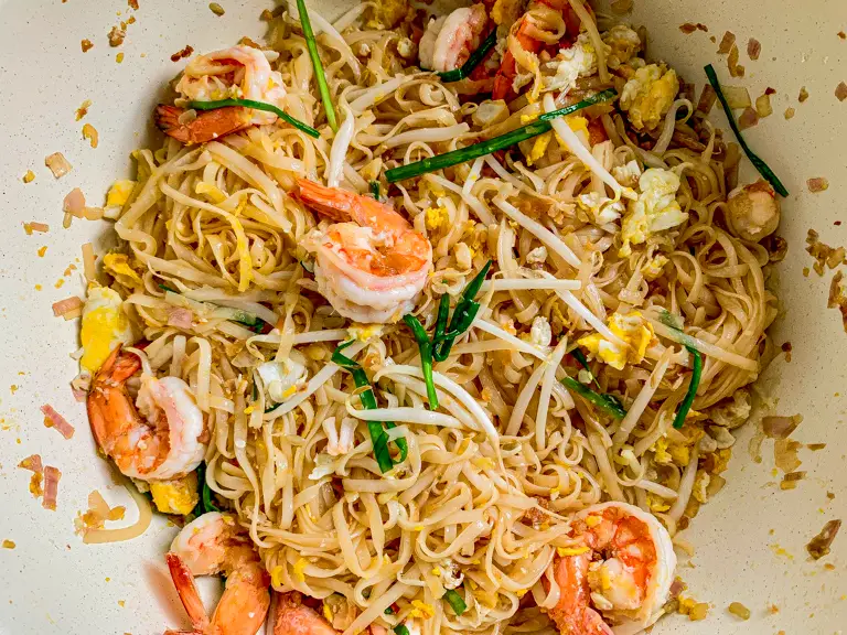 Final shrimp pad Thai with scrambled eggs, bean sprouts, and garlic chives.