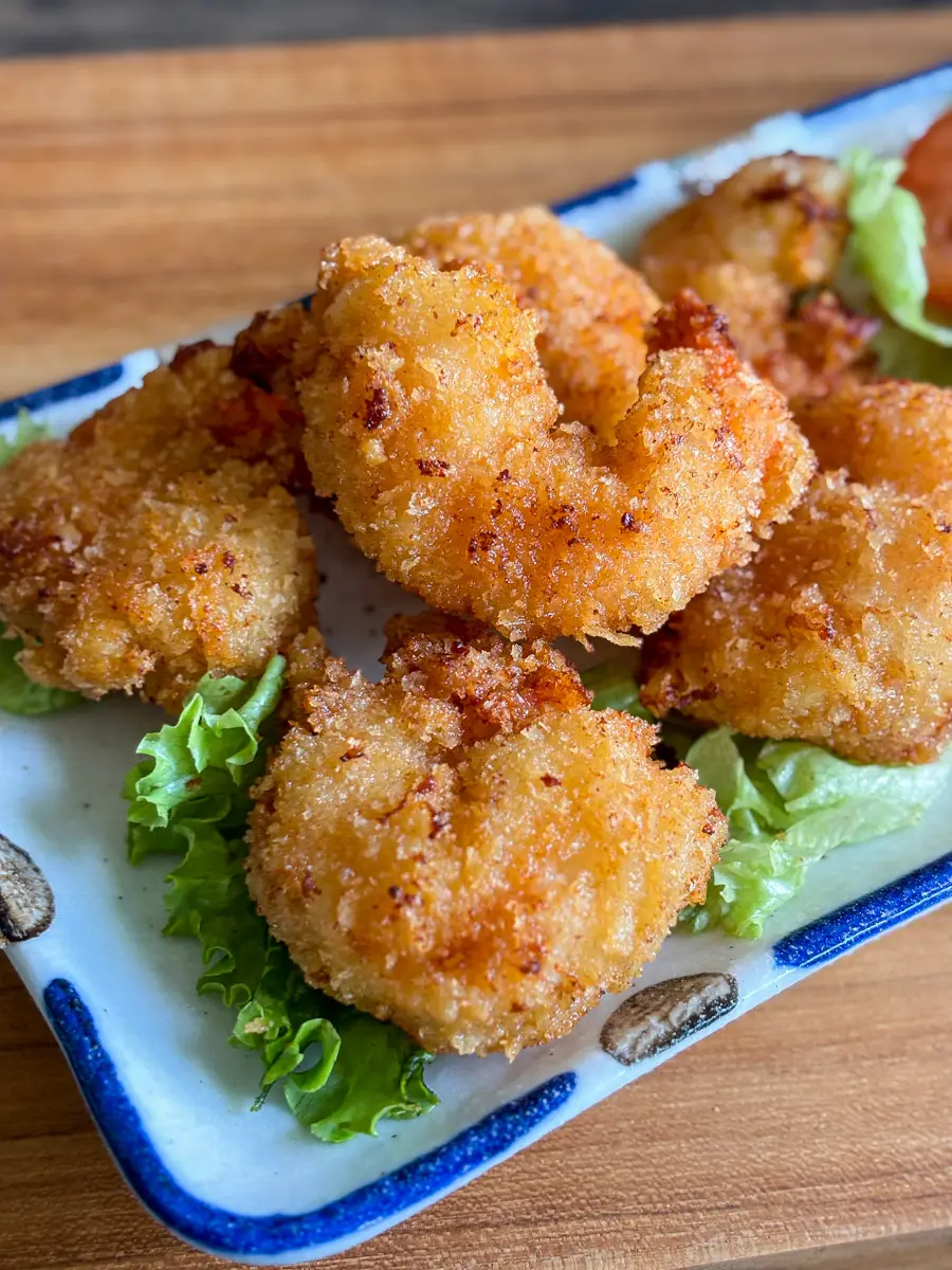 Close-up of golden fried panko shrimp with crunchy breadcrumbs coating on plate.