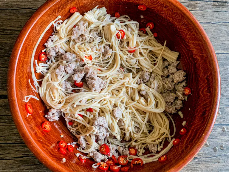 Enoki mushroom salad tossed with chilies, lime juice, and fish sauce dressing.