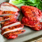 Juicy grilled char siu chicken thighs sliced and served with bok choy.