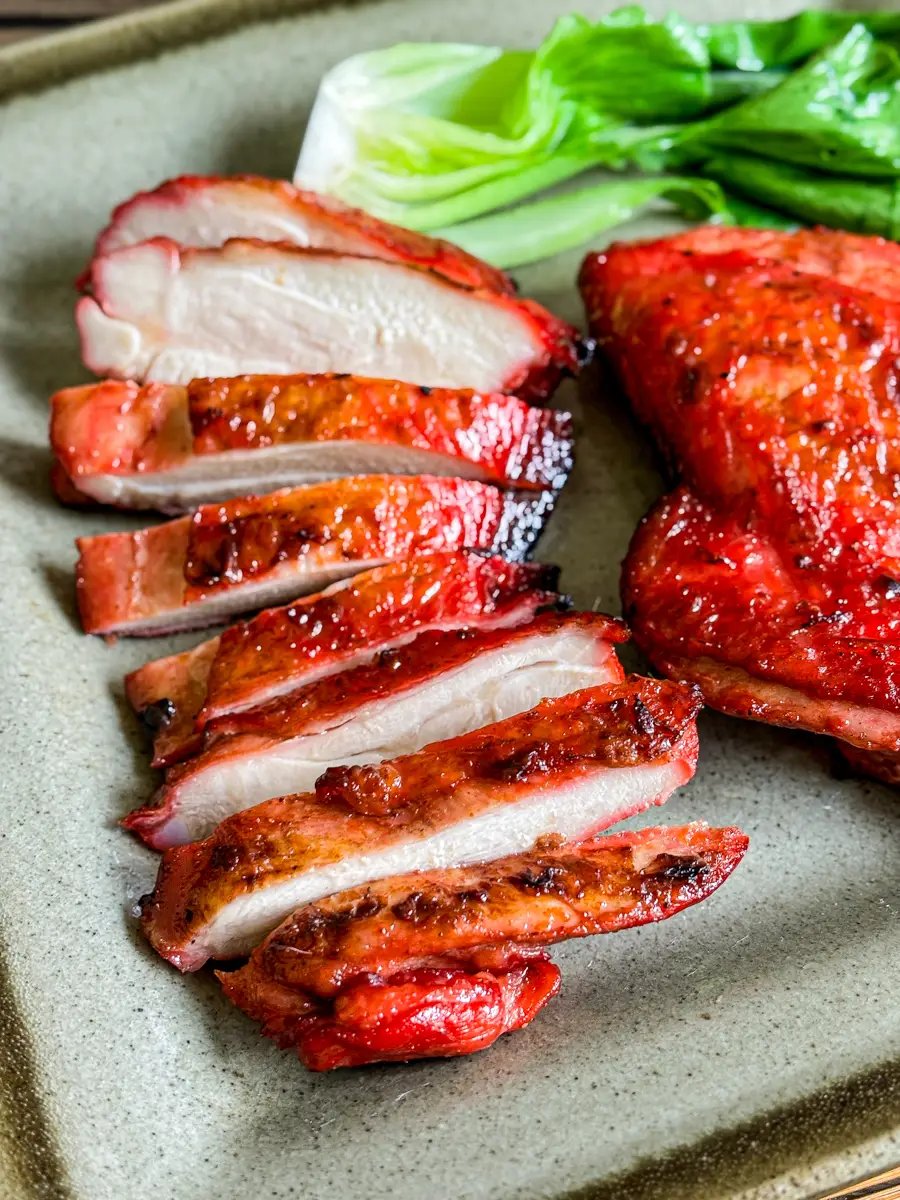 Close-up of sliced char siu chicken showing crispy edges and juicy center.