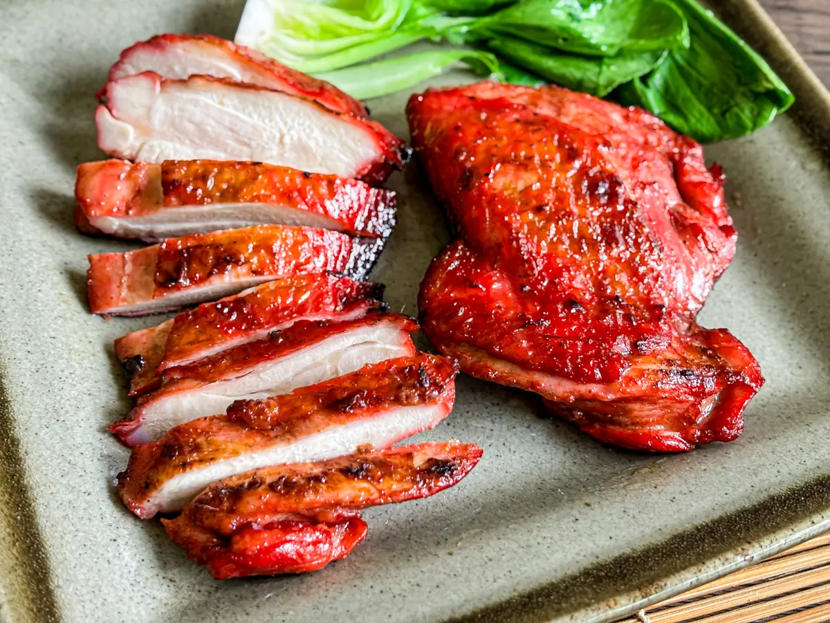 Juicy grilled char siu chicken thighs sliced and served with bok choy.
