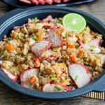 Char siu fried rice with red pork slices, diced carrots, and chopped scallions.