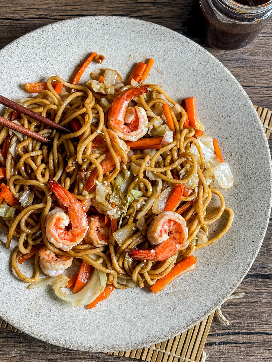 Plate of shrimp yakisoba with stir-fried noodles, vegetables, and a glossy homemade sauce.